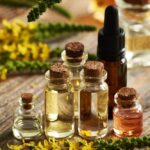 Essential oil bottles with herbs to aid lymphatic drainage.