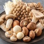 Various mushrooms beneficial for brain health on a dark plate.