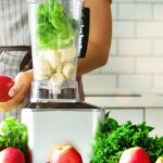 Woman preparing a healthy smoothie with greens and fruits in a blender.