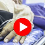Close-up of elderly patient's hand with an IV in a hospital setting.