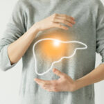 Person with glowing liver outline on stomach, symbolizing detox.