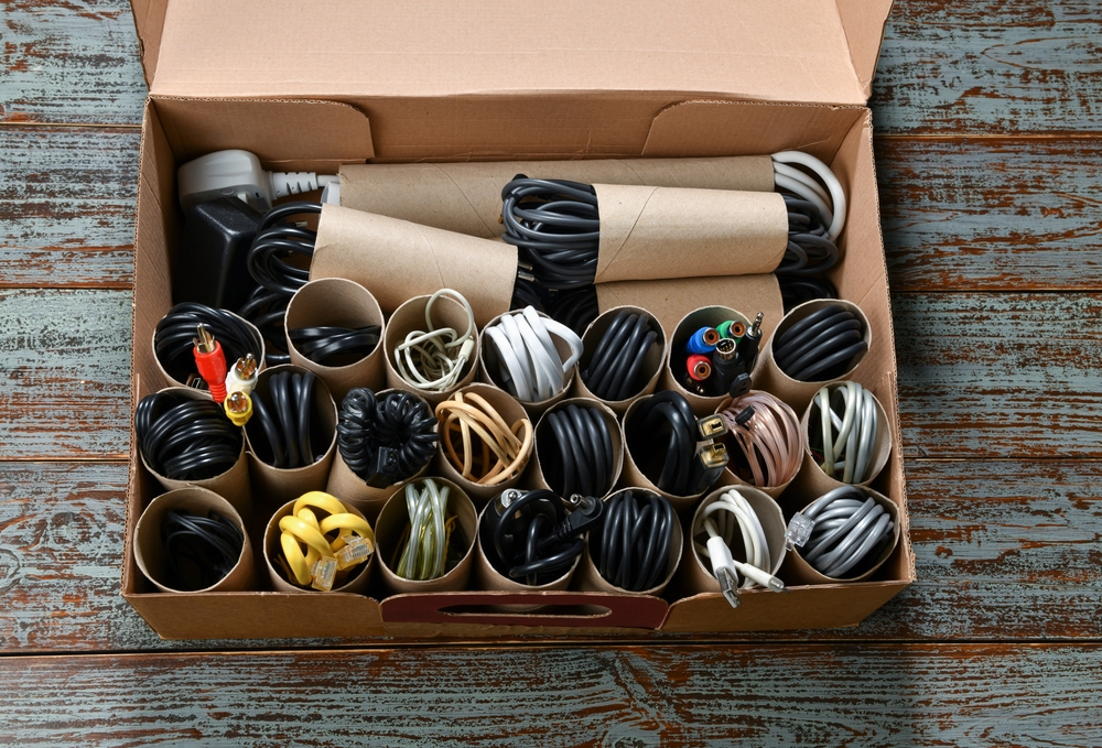 a box neatly organized with cables and cords stored in cardboard rolls for easy separation and storage.