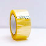 a roll of clear packing tape with a paperclip attached to the edge as a simple hack to easily locate and lift the tape's end.